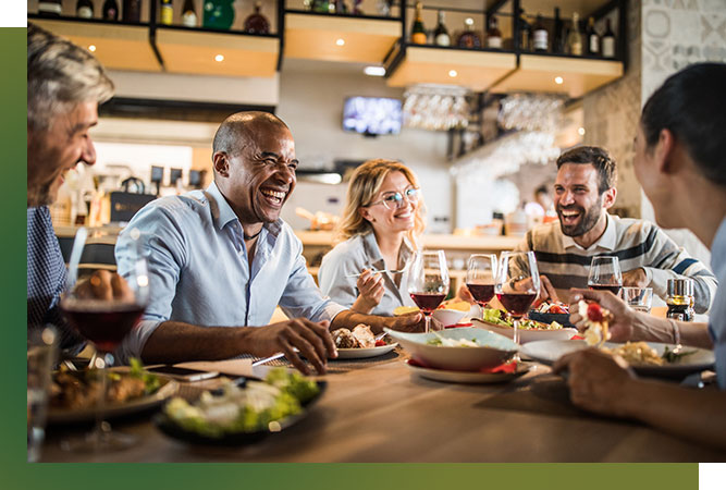 group of friends having lunch and drinks. Everyone is laughing